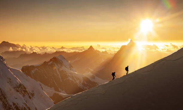 Poster Climbers on a snowy ridge at sunrise