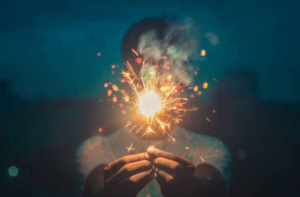 Poster Cropped hands holding sparkler at night,Bangladesh