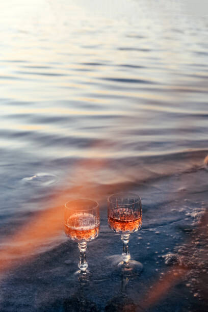 Poster Glasses of champagne on the beach. Alcoholic drink outdoors. Unusual drink.