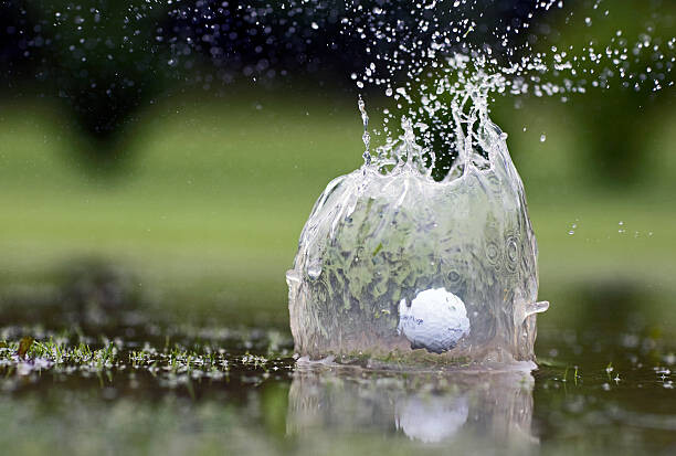 Poster Golf ball landing in pond, close-up