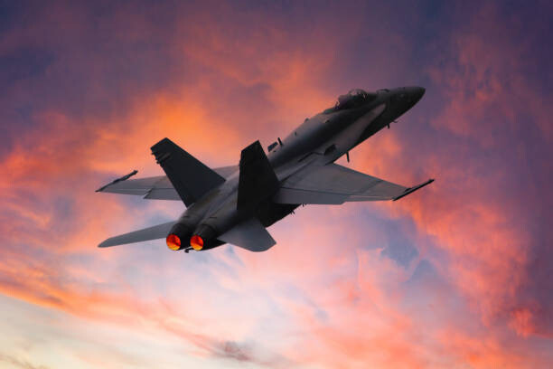 Poster Military fighter aircraft in the sky at sunset