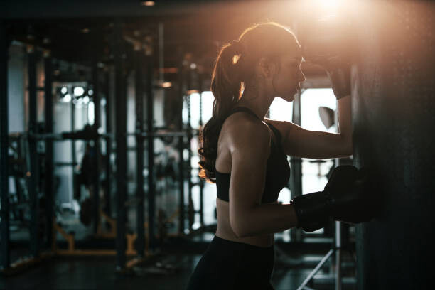 Poster Tired woman wearing boxing gloves leaning