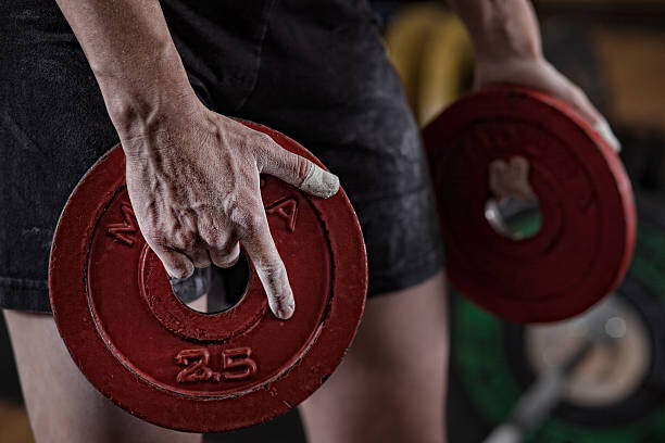 Poster Woman holding plate weights