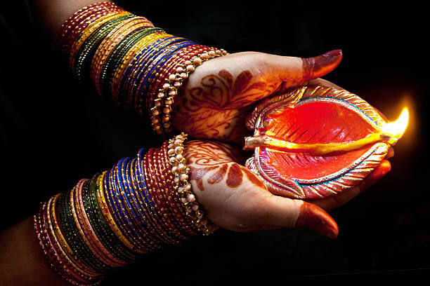 Poster Woman with lit earthen lamp at Diwali festival