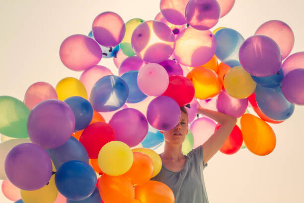 Poster Young woman walking with many balloons
