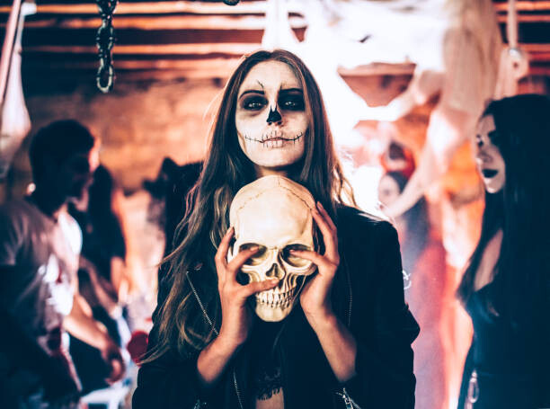Poster Young woman with skeleton make-up holding