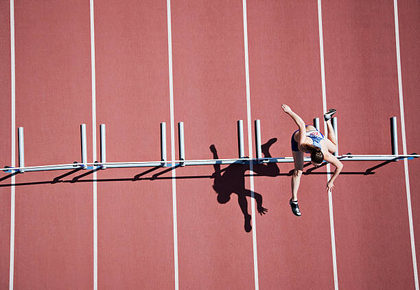 Αυτοκόλλητο Runner jumping hurdles on track