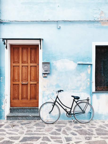 Quadro em tela Bicycle parked against blue wall in a village