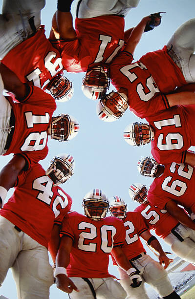 Quadro em tela Football team in huddle, low angle view