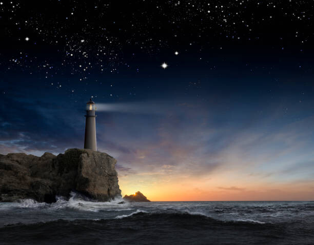 Фототапет Lighthouse beaming over rocky ocean waves