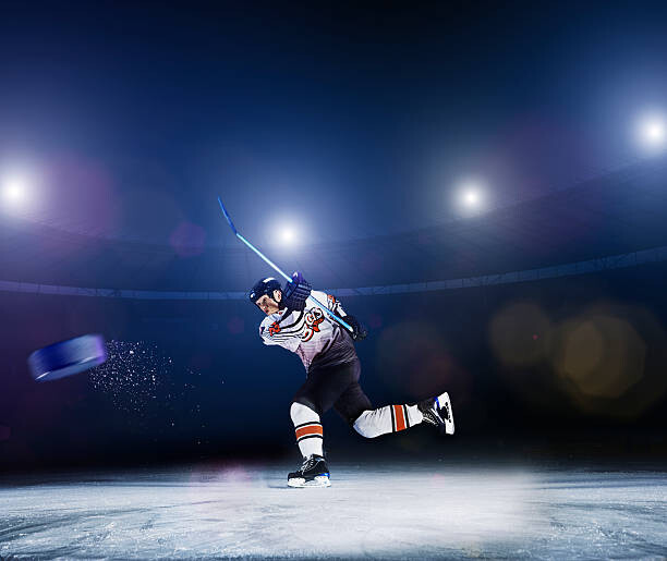 Αφίσα Ice hockey player shooting puck.