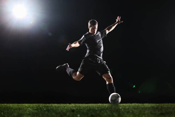 Αφίσα Soccer player kicking ball on grass,