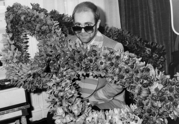 Εκτύπωση καμβά English Singer Elton John at his Arrival in Paris : Bunch of Flowers in The Shape of Glasses He Wears, December 1St, 1976