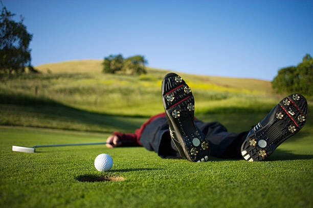 Εκτύπωση καμβά Golfer lying on green, ball on edge of hole