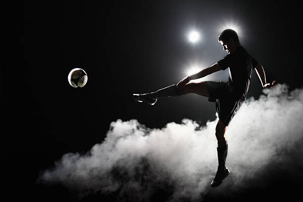 Εκτύπωση καμβά Soccer player kicking the ball at night on stadium